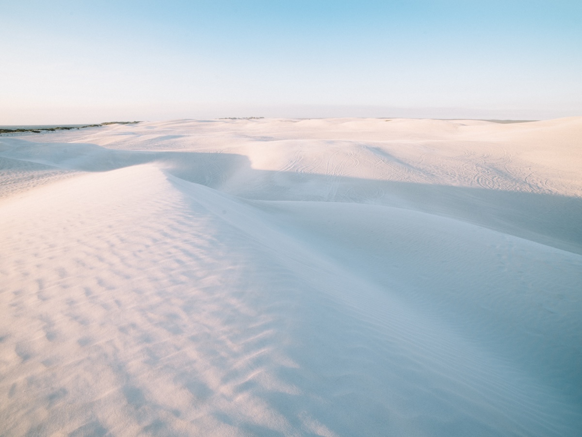 Expansive white sand dunes at Lancelin, Western Australia, with clear blue skies