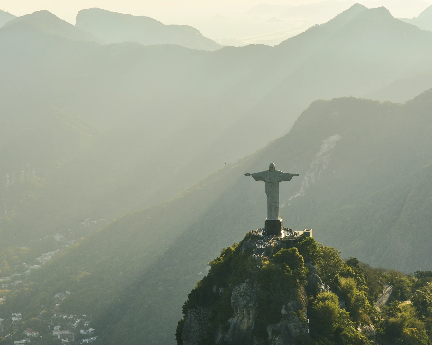 Aerial view of the Christ the Redeemer statue on Corcovado Mountain with soft sunrise light over the mountains in Rio de Janeiro, Brazil