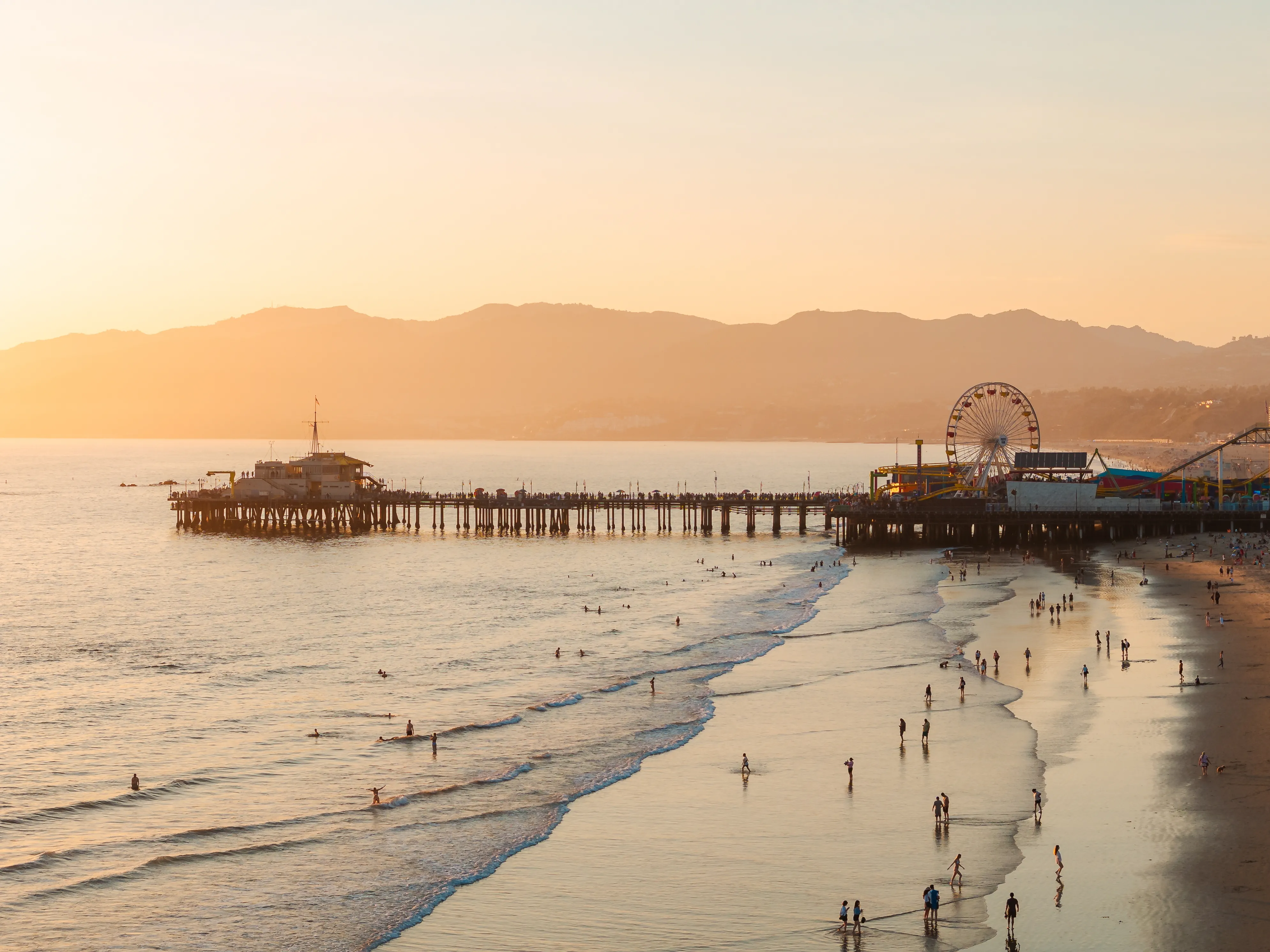 Golden sunset over Santa Monica Pier and beach in Los Angeles, California — reachable on a direct flight from Sydney or Melbourne.