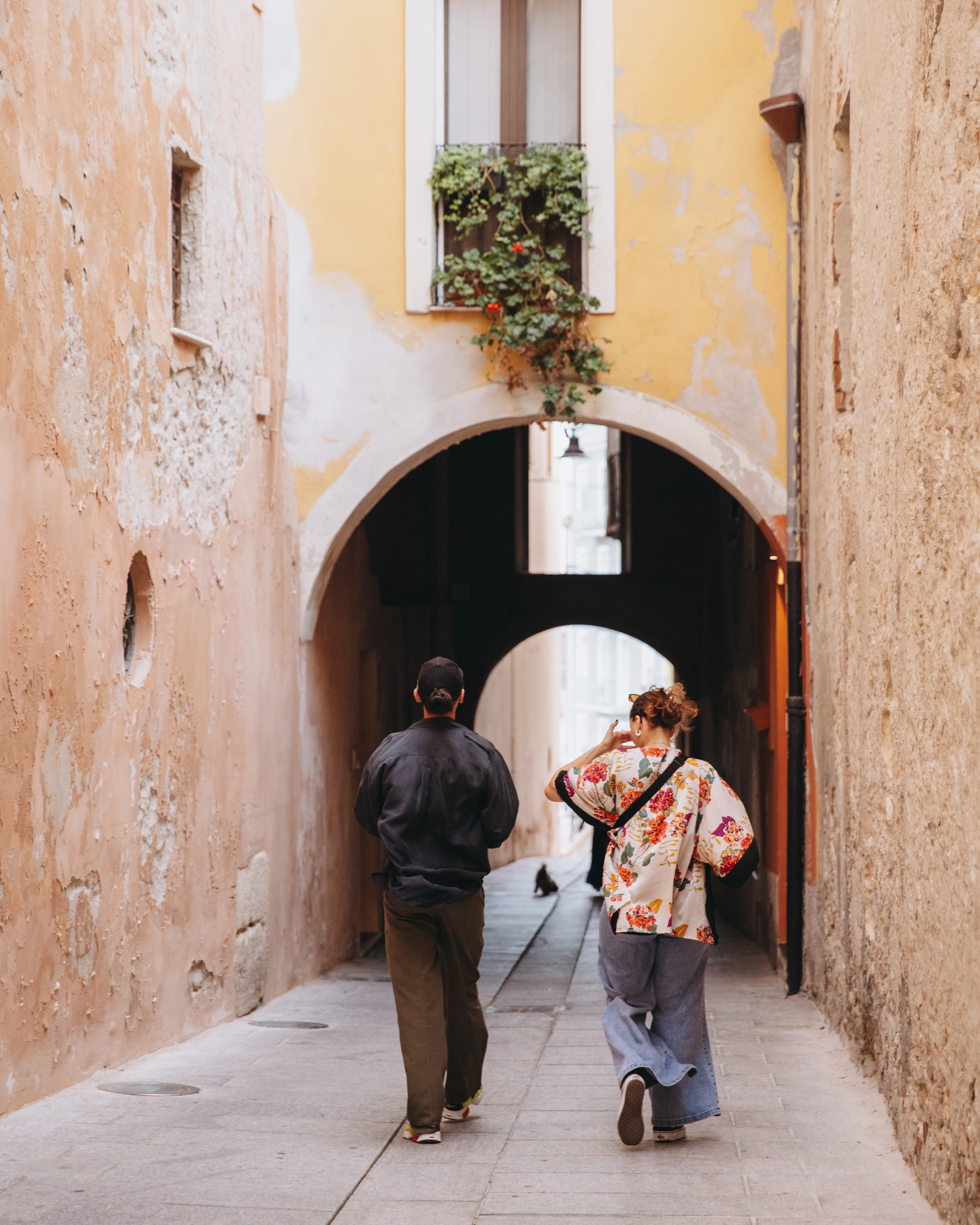 Travellers walking through a historic alleyway in Italy, showcasing the culture, architecture and charm of an Italian city in September.
