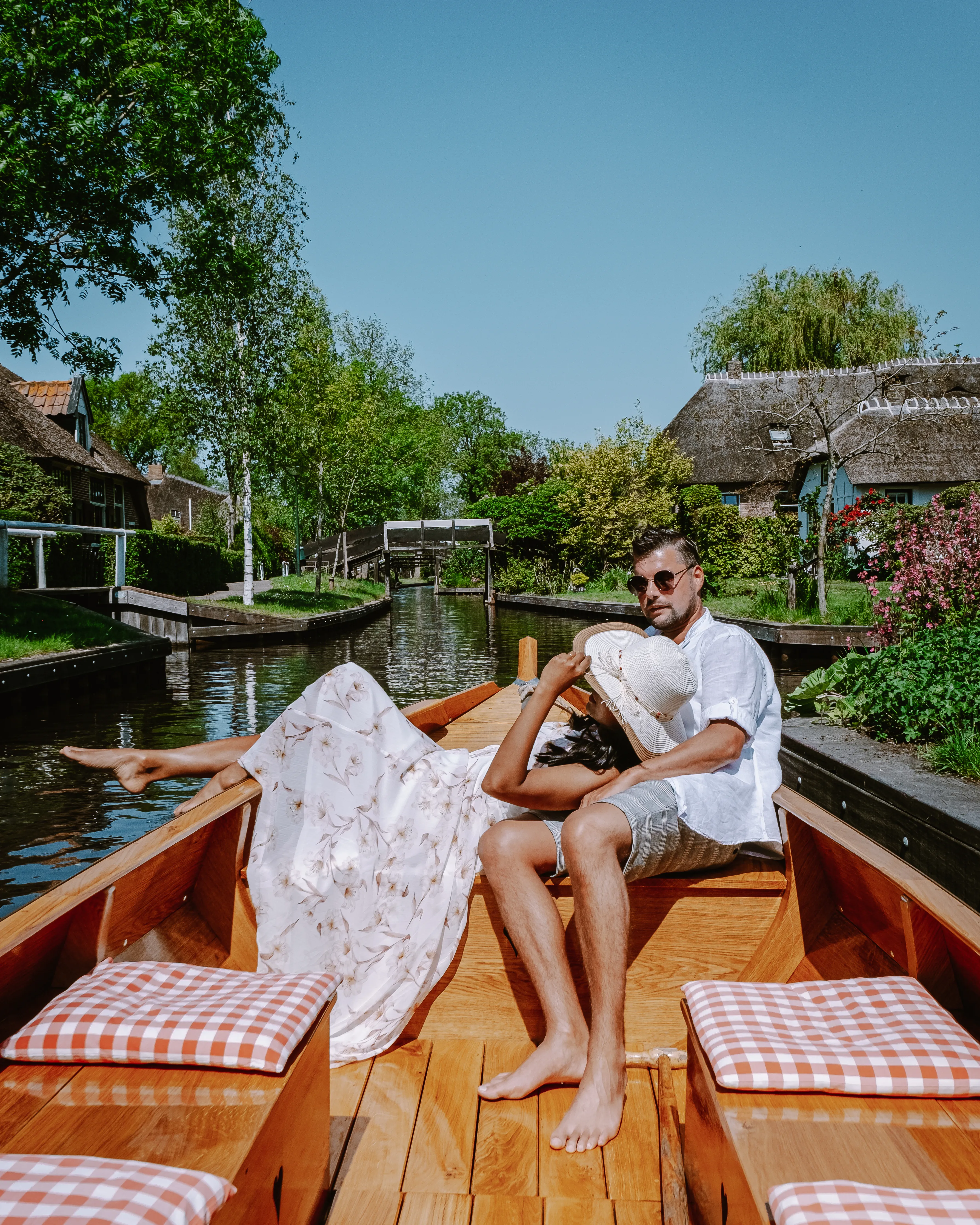 Couple relaxing in a traditional boat along the canals of Giethoorn, a popular day trip destination from Amsterdam.
