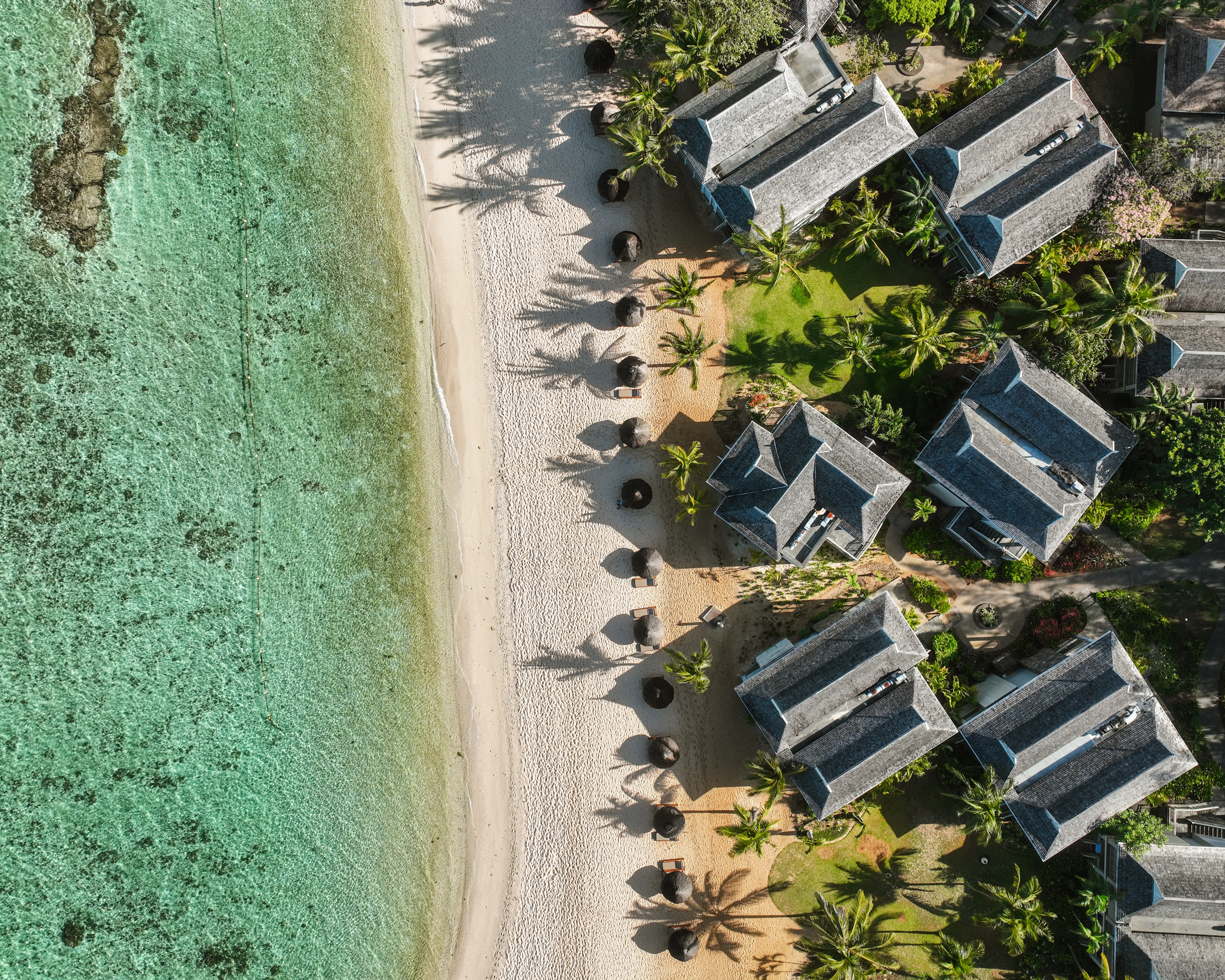 Aerial view of a Mauritius beachfront resort, white sand beach and clear lagoon during the island's dry season in September