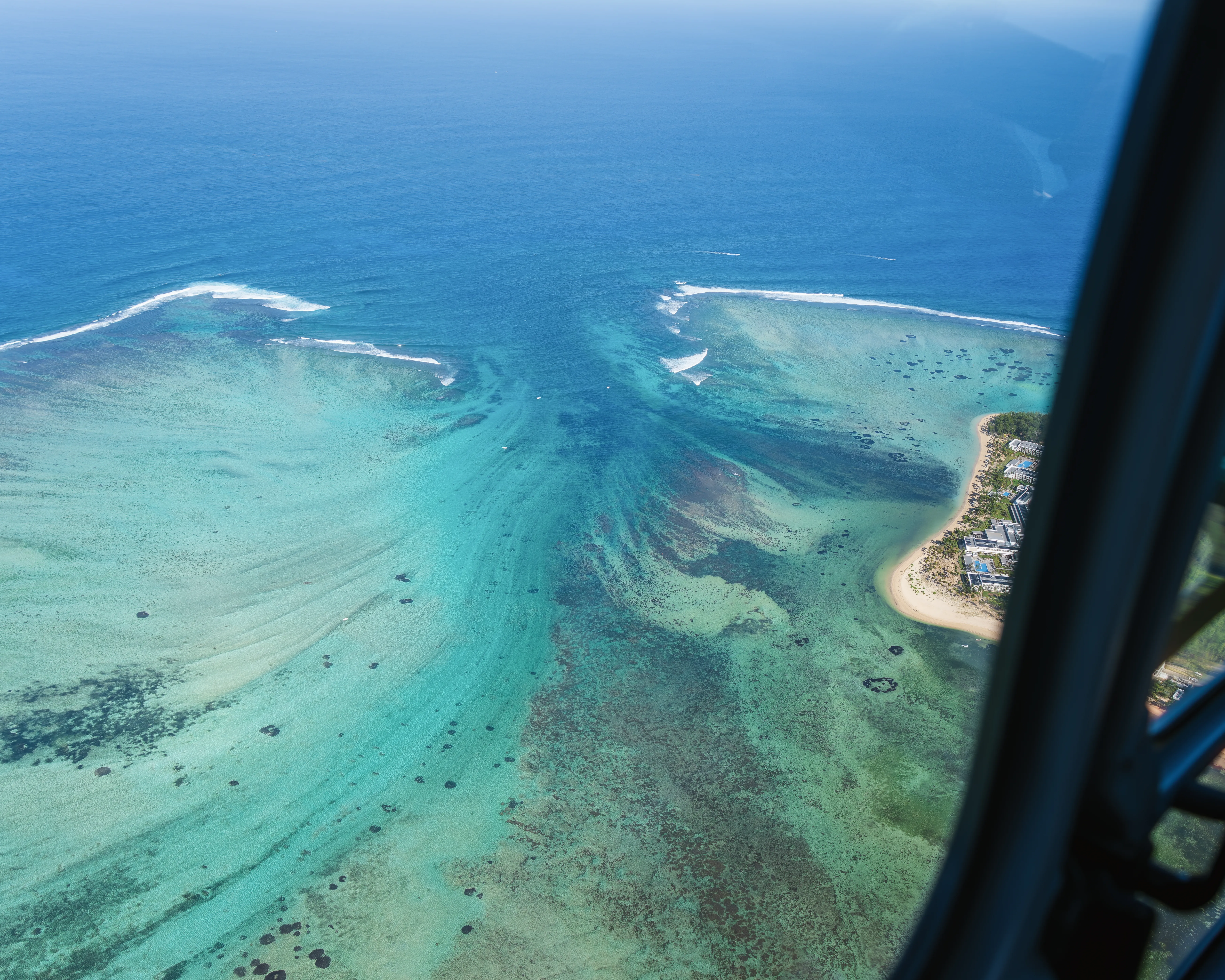 Aerial view of Mauritius lagoon, coral reef and white sand coastline, one of the best tropical destinations to visit in September from Australia.